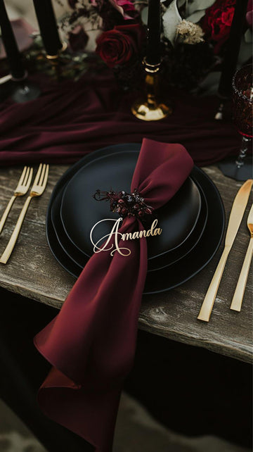 Gold name tag “Amanda” on black plate with deep red ribbon and candle